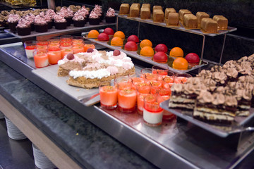 Selection of desserts at a dessert and cake buffet, served on stainless steel tables