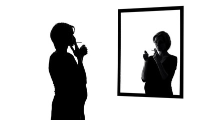 Pregnant woman smoking cigarette, looking in mirror, conscience asking to stop
