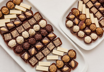 Small assorted cakes lined up in rows on dessert buffet