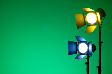 Equipment for photo studios and fashion photography. Green background. Ready to shoot photo scheme concept. Blue and yellow light on reflector.