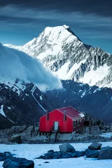 Papier Peint photo Aoraki/Mount Cook Winter landscape view of red mountain hut and Mt Cook peak, NZ