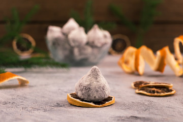 Chocolate truffle with powdered sugar powder, dried lemon slices, Christmas decorations.