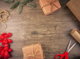 Christmas gift box and wrapping tools flat lay on wooden background with copy space