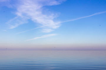 Obraz premium Summer seascape. Skyline in the ocean. The colors of nature. Clear sky. Water surface Reflection of the sky in the water.