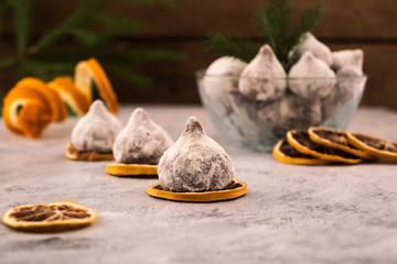 Chocolate truffles in powdered sugar, bright slices of dried lemon, a beautiful dessert for the holiday.