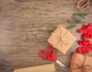 Christmas gift box and wrapping tools flat lay on wooden background with copy space