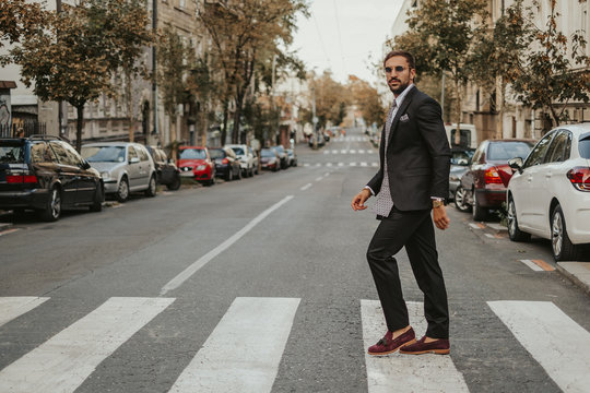 Elegant bearded businessman crossing the street