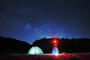 Man With Red Headlamp Looking In Camera Near Lighting Tent © ollirg