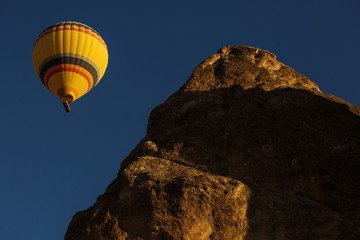 Fototapeta na wymiar Colorful hot air balloon flying over a beatiful blue sky in background