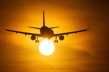 Air plane taking off at sunset near to the sun with beautiful red cloud in background