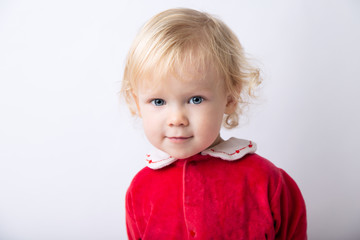 Naklejka premium Portrait of cute cute baby girl 1.5 years old, in red clothes close-up on a white light background. concept christmas