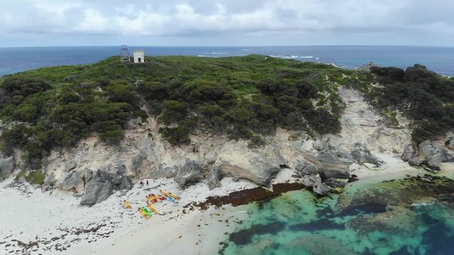 rotating view of an island in Western Australia's south west over a blue contrasting ocean with a white kayaks on a white sand beach