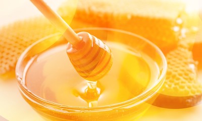 Honey and  wooden spoon  on background