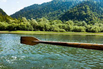 A wooden paddle on a boat Blade of wooden kayak or canoe paddle Water splash  