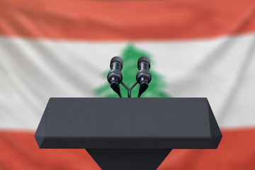 Podium lectern with two microphones and Lebanon flag in background