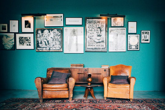 Home decoration. leather armchairs with a old carpet and wall frames