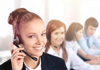 Beautiful businesswoman portrait with headset , colleagues