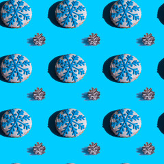 Seamless background with gingerbread in the form of snowflakes, fir cones on a vivid blue background. Hard shadows.Abstract art christmas background. Minimal print concept. Flat lay food