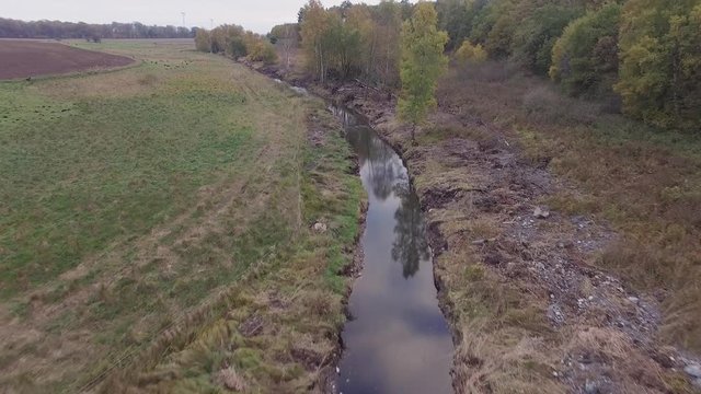 aerial - flying over a small stream on the countryside