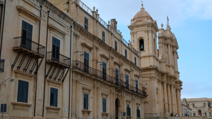 Fototapeta na wymiar Noto, province of Syracuse, Sicily. View of the building at the left of St Nicholas Cathedral, that it can see in the background. Both buildings are representative of the sicilian baroque.