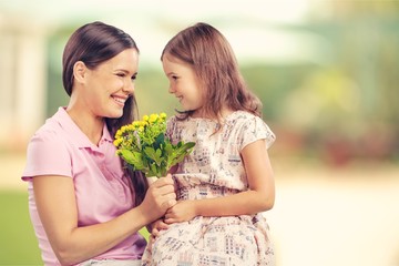 Fototapeta na wymiar Happy Mother and daughter together with flowers