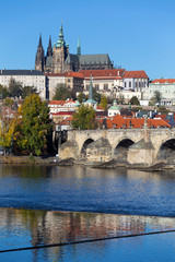 Obraz premium Colorful autumn Prague gothic Castle and Charles Bridge with the Lesser Town in the sunny Day, Czech Republic