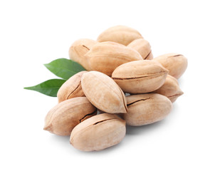 Heap of pecan nuts in shell and leaves on white background