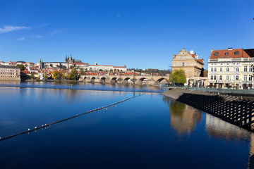 Fototapeta na wymiar Colorful autumn Prague gothic Castle and Charles Bridge with the Lesser Town in the sunny Day, Czech Republic