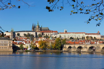 Fototapeta premium Colorful autumn Prague gothic Castle and Charles Bridge with the Lesser Town in the sunny Day, Czech Republic