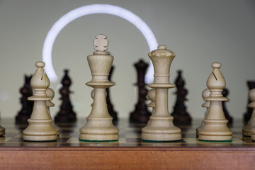 background. wooden chess pieces (white / black) placed on a chessboard