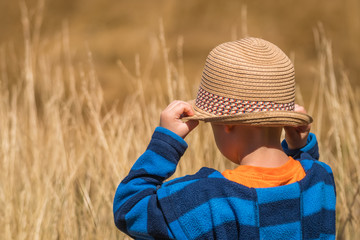 Boy with a straw hat in a countryside