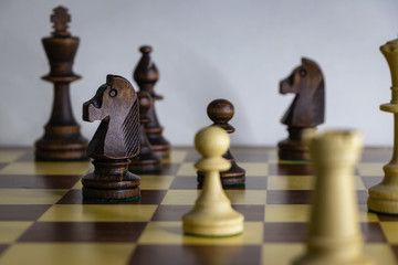 background. wooden chess pieces (white / black) placed on a chessboard