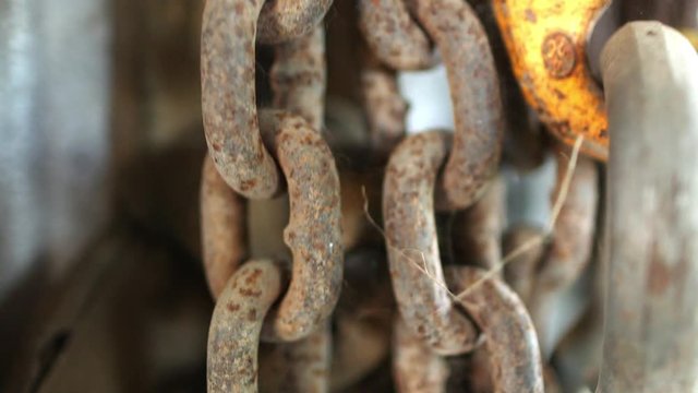 Static pull focus close up footage of old heavy chain and links covered in rust and grime.