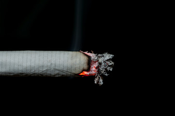 Smoking cigarette on black background