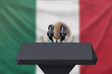 Podium lectern with two microphones and flag in background