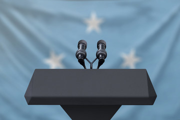 Podium lectern with two microphones and Micronesia flag in background