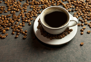Sparkling Coffee cup and beans with bright light on black rustic vintage table,Sparkling Coffee concept background.