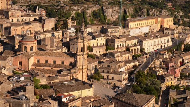 Landscape of Modica, Sicily - Italy. The Catholic Church (Cathedral of San Giorgio) can be seen in the midle of the image. Cars pass by. 