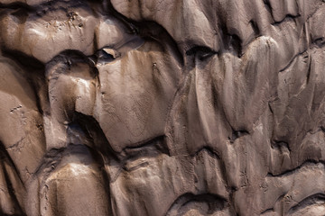 Glacial riverbank shore with wet black silt sand mud