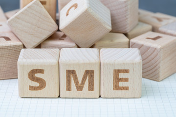 SME, small and medium-sized enterprises concept, cube wooden block with alphabet combine the word...