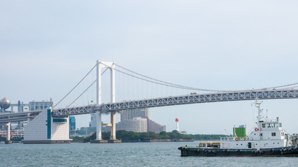 Boat on Sumida river with background on the beautiful Tokyo Rainbow Bridge.