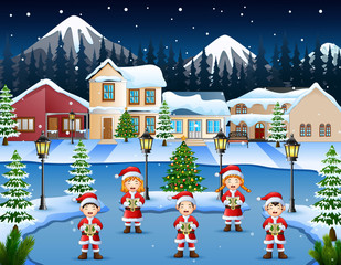 Obraz na płótnie Canvas Happy children singing christmas carols in winter night landscape