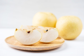 Sliced Asian pear fruit on wooden plate ready for eating