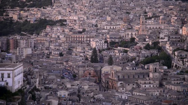 City of Modica, Sicily - Italy framed after the sunset. While the headlights of the cars are already lit, the lights of the city begin to be turned on. Image with sound
