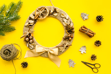 Process of making christmas wreath concept. Creative christmas wreath made of thread near matherials and instruments, sciccors on yellow background top view copy space