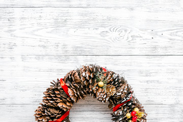 Christmas wreath made of pine cones on white wooden background top view copy space