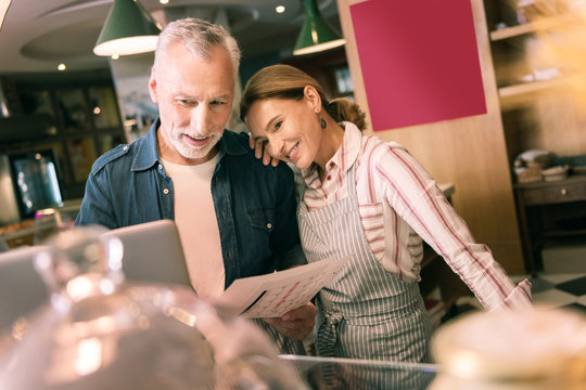 Lean on shoulder. Happy beautiful woman leaning on shoulder of her smart successful businessman