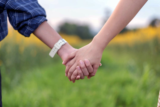Rear view of two teens student together holding hand in hand