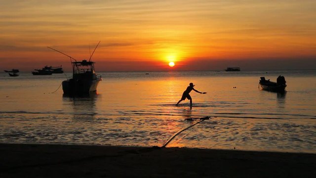 man relaxing on sea beach against sunset sky