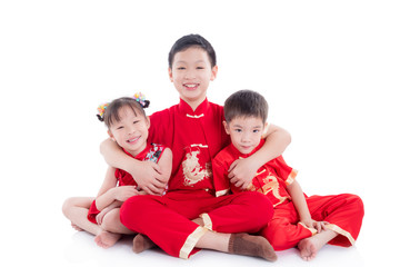 Group of chinese children wearing traditional costume sitting and smile on the floor over white...